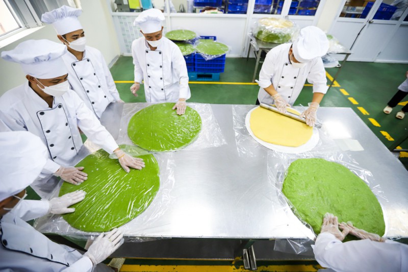 Thay vì làm một chiếc lớn, những người nghệ nhân phải dàn bánh thành từng lớp vỏ và nhân riêng biệt sau đó mới ghép lại, tạo hình.